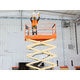 A JLG 2646ES 9.92m Electric Scissor Lift being used inside a warehouse.