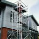 Scaffold tower erected outside next to a building.